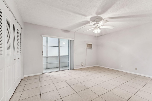 unfurnished bedroom with a wall mounted air conditioner, a textured ceiling, ceiling fan, and light tile patterned flooring