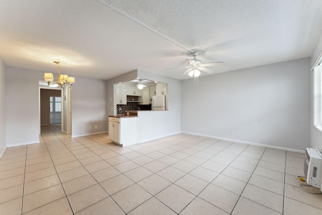 unfurnished living room with a textured ceiling, light tile patterned floors, and ceiling fan with notable chandelier