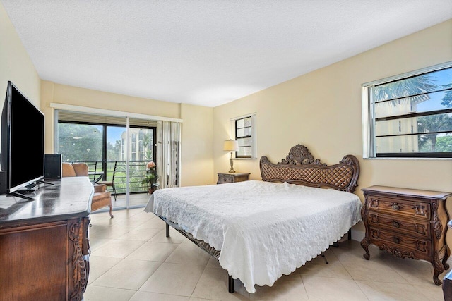 tiled bedroom with access to exterior and a textured ceiling