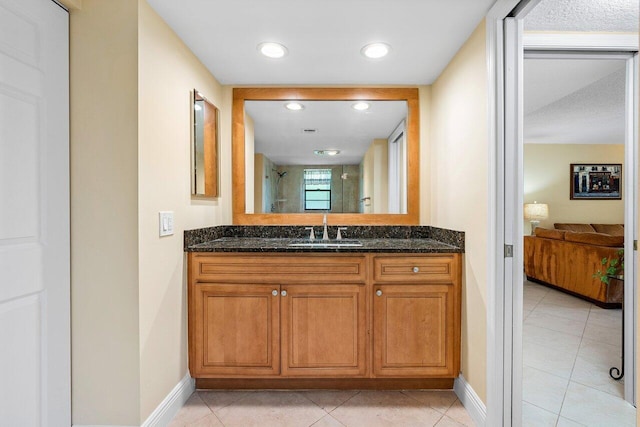 bathroom featuring tile patterned floors, vanity, and a shower