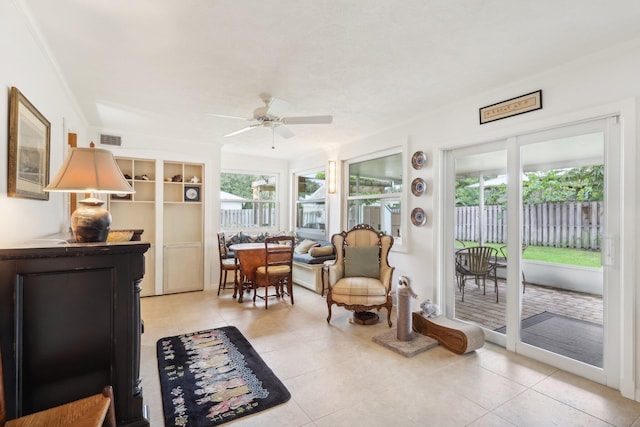 living area with ceiling fan, crown molding, and light tile patterned flooring