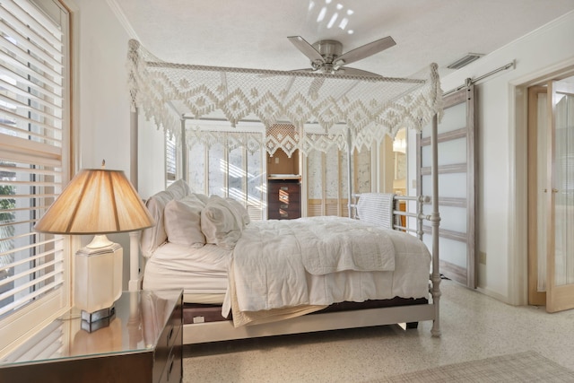 bedroom with a barn door, ceiling fan, and crown molding