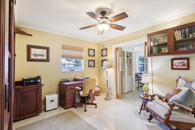 carpeted home office featuring ceiling fan and ornamental molding