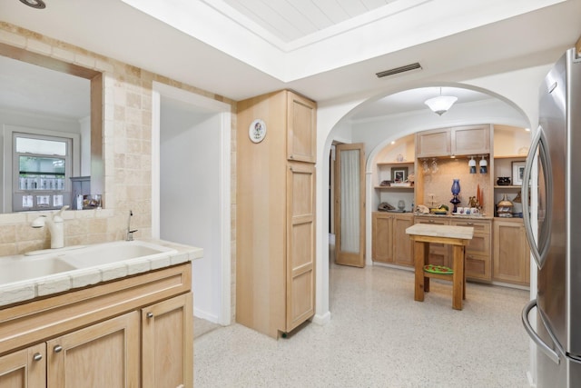 kitchen featuring stainless steel fridge, tile counters, and sink