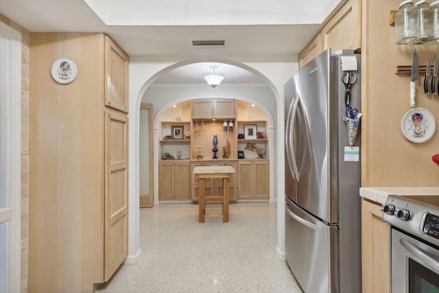 kitchen with light brown cabinets and appliances with stainless steel finishes