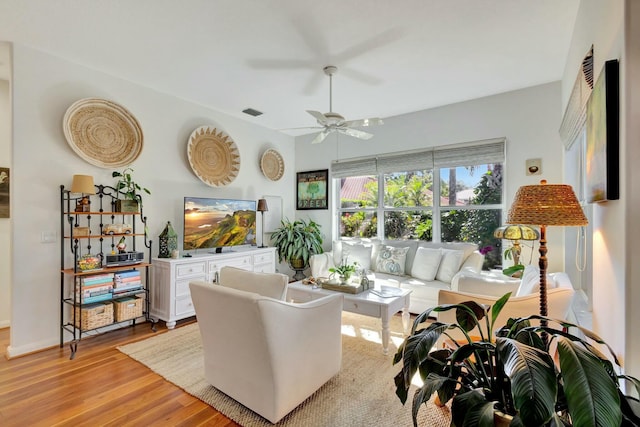 living room featuring ceiling fan and light hardwood / wood-style flooring