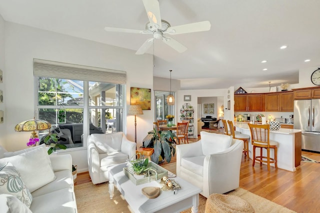 living room with ceiling fan and light hardwood / wood-style floors