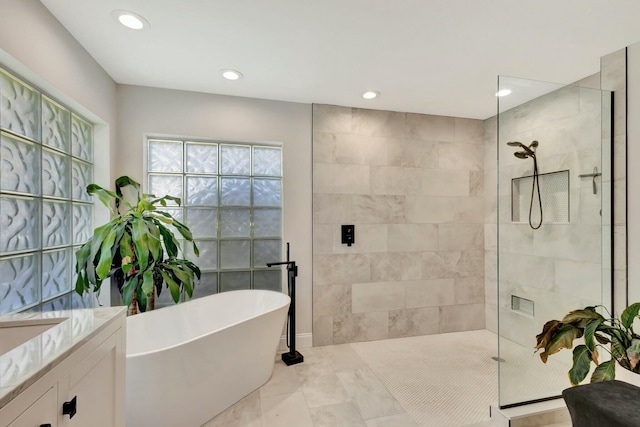 bathroom with tile patterned floors, vanity, and plus walk in shower