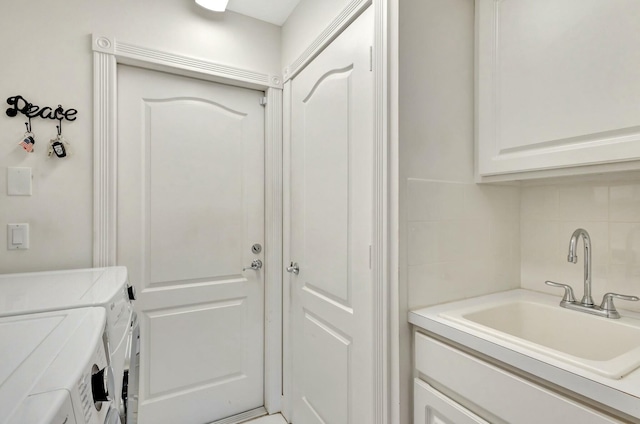 washroom with washer and clothes dryer, cabinets, and sink