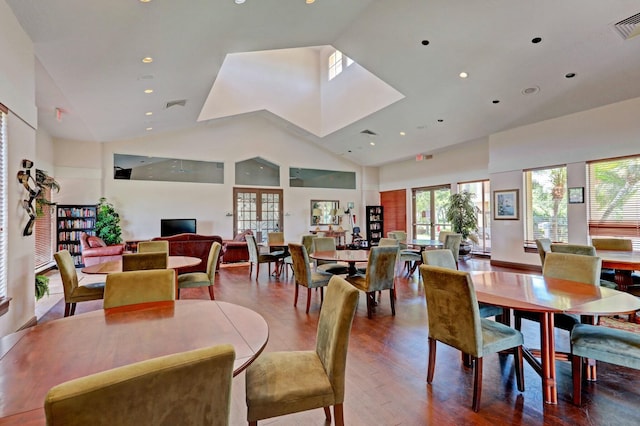 dining space featuring hardwood / wood-style flooring and high vaulted ceiling