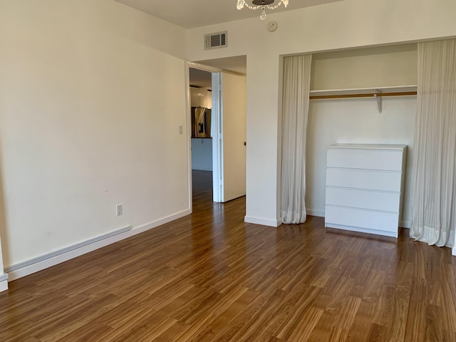 unfurnished bedroom featuring dark wood-type flooring and a closet