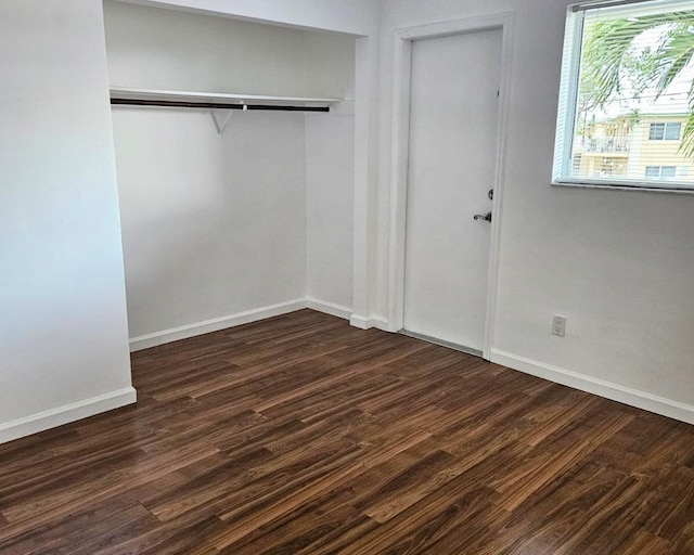 unfurnished bedroom featuring a closet and dark hardwood / wood-style floors