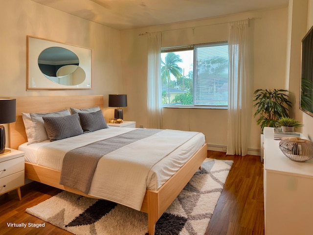 bedroom with dark wood-type flooring and a baseboard radiator