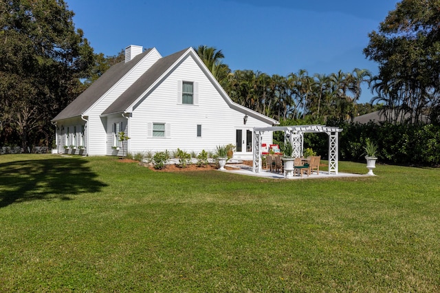 rear view of property featuring a lawn, a pergola, a patio area, and french doors