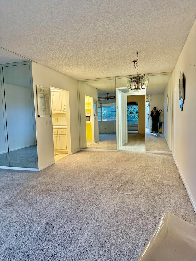 unfurnished living room featuring light colored carpet and a textured ceiling