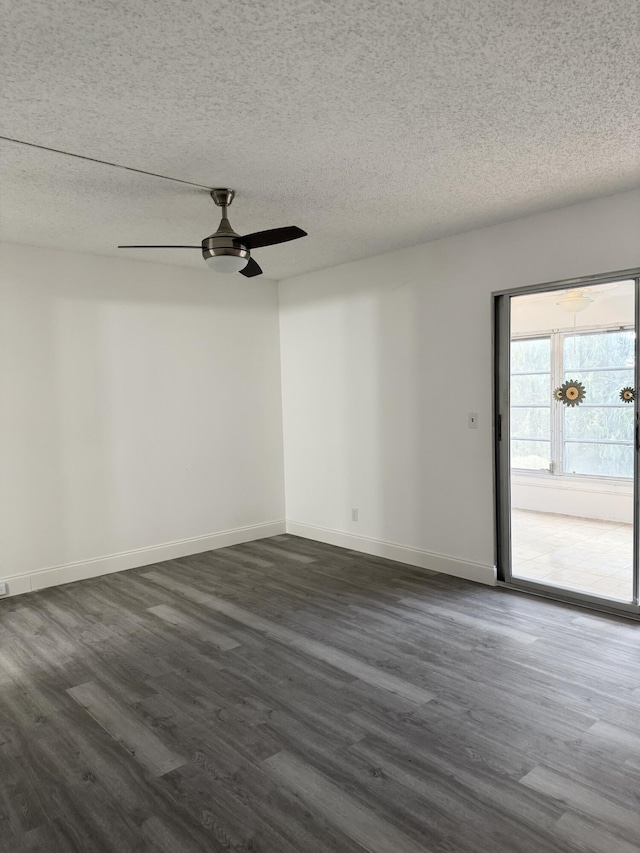 unfurnished room with a textured ceiling, dark wood finished floors, and baseboards