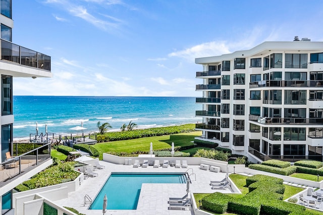 view of pool featuring a water view and a patio