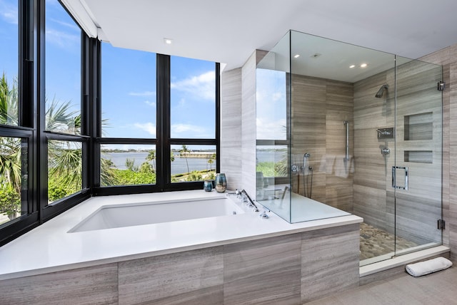 bathroom featuring a water view and independent shower and bath