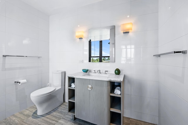 bathroom featuring vanity, tile walls, and toilet