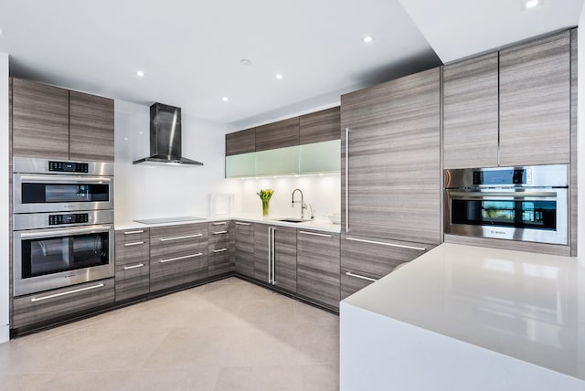 kitchen featuring wall chimney range hood, sink, double oven, and black electric cooktop