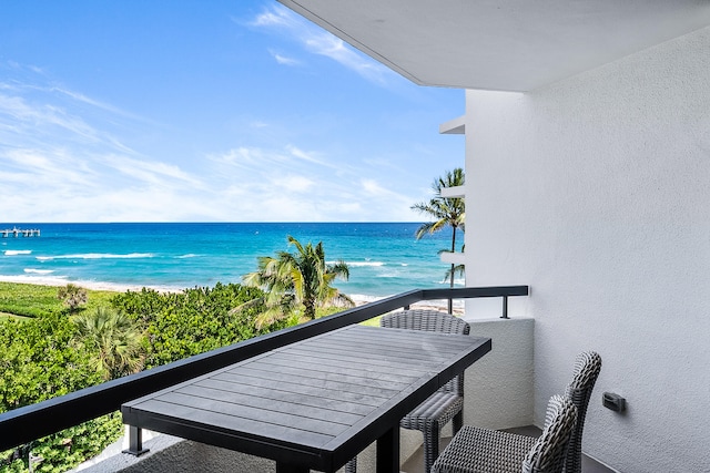 balcony with a water view and a view of the beach