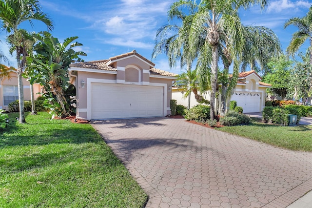 mediterranean / spanish home with a garage and a front lawn