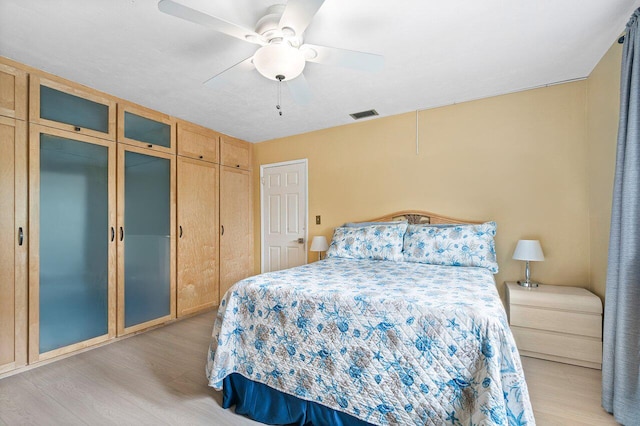 bedroom with light hardwood / wood-style floors and ceiling fan