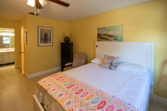 bedroom with a textured ceiling, ceiling fan, and ensuite bathroom