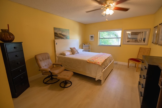 bedroom featuring a textured ceiling, light wood-type flooring, and ceiling fan