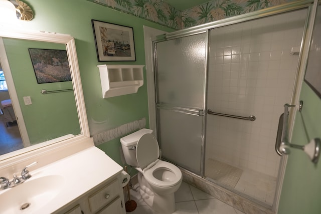 bathroom with tile patterned floors, vanity, toilet, and a shower with shower door