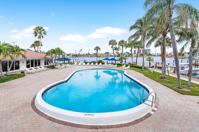 view of pool featuring a patio area and a water view