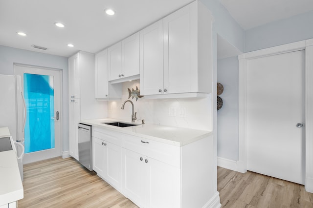 kitchen with white cabinetry, dishwasher, sink, and light hardwood / wood-style flooring