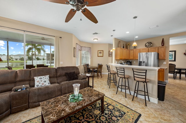 tiled living room featuring ceiling fan and sink