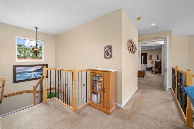 bedroom with light colored carpet, ceiling fan, and a tray ceiling