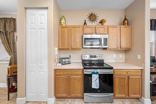 kitchen featuring light brown cabinets and appliances with stainless steel finishes