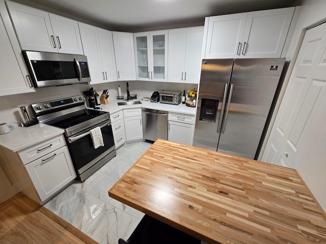 kitchen featuring white cabinets, sink, and appliances with stainless steel finishes