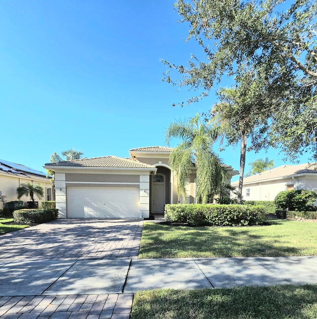 view of front of property with a garage and a front lawn