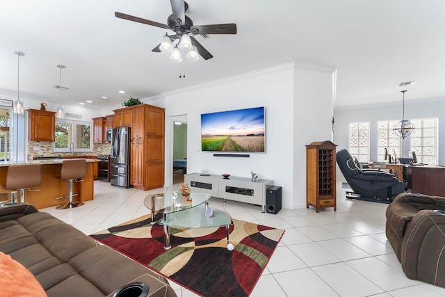 living room with ceiling fan, a healthy amount of sunlight, light tile patterned floors, and crown molding