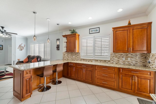 kitchen featuring pendant lighting, ceiling fan, kitchen peninsula, and crown molding