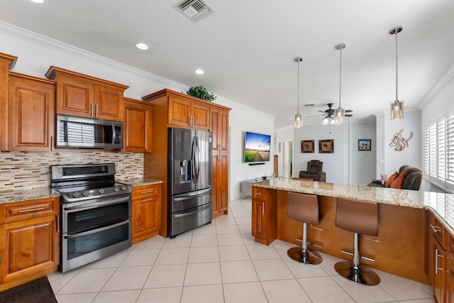 kitchen with a breakfast bar, stainless steel appliances, ceiling fan, crown molding, and pendant lighting