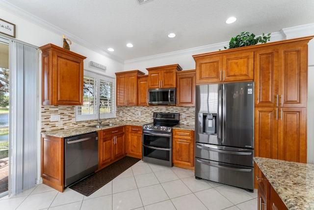 kitchen with sink, light stone countertops, ornamental molding, tasteful backsplash, and stainless steel appliances