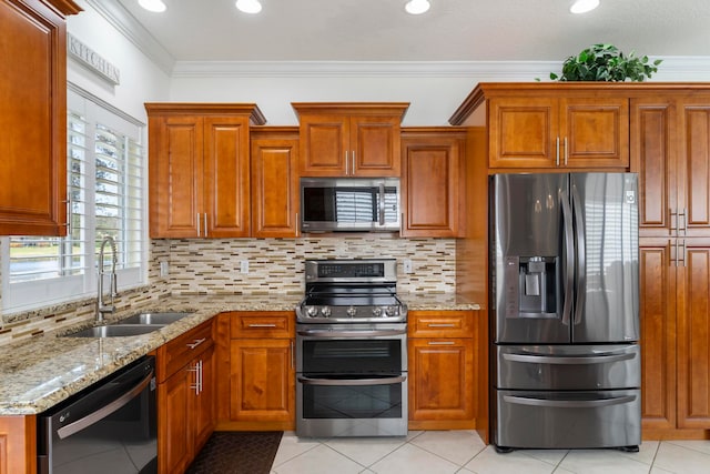 kitchen with sink, stainless steel appliances, light stone counters, light tile patterned flooring, and ornamental molding