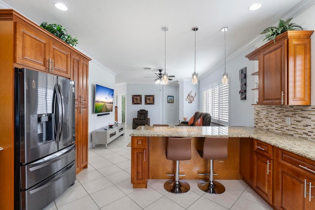 kitchen with kitchen peninsula, plenty of natural light, decorative light fixtures, and stainless steel refrigerator with ice dispenser