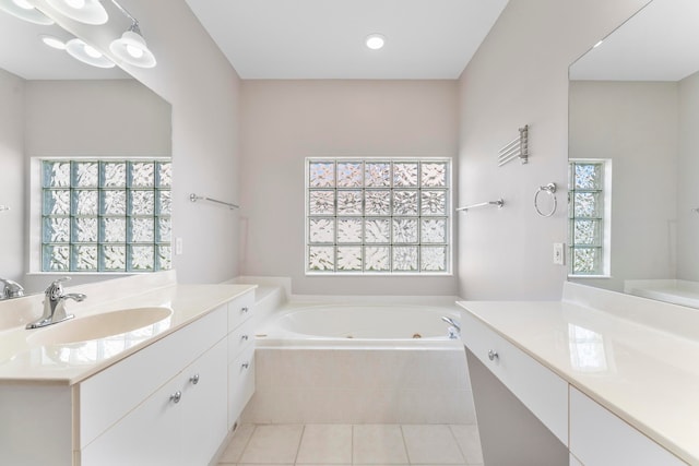 bathroom featuring tile patterned flooring, vanity, and tiled tub