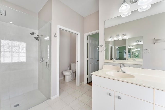 bathroom with tile patterned flooring, vanity, a shower with shower door, and toilet