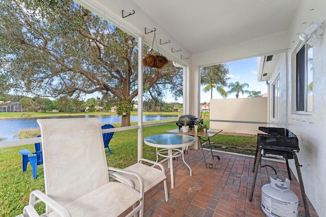 sunroom / solarium featuring a water view