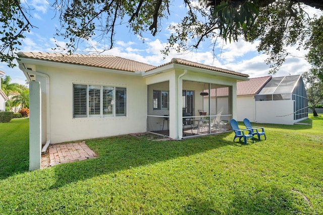 back of property featuring a lawn and a sunroom