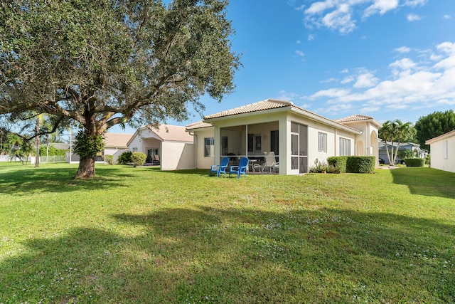 back of property featuring a lawn and a sunroom