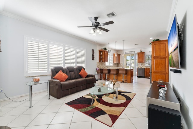 tiled living room with plenty of natural light, ceiling fan, and ornamental molding