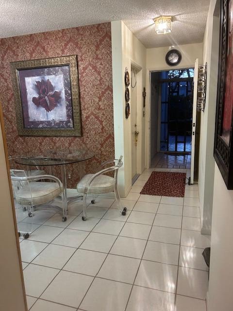 hallway featuring light tile patterned flooring and a textured ceiling